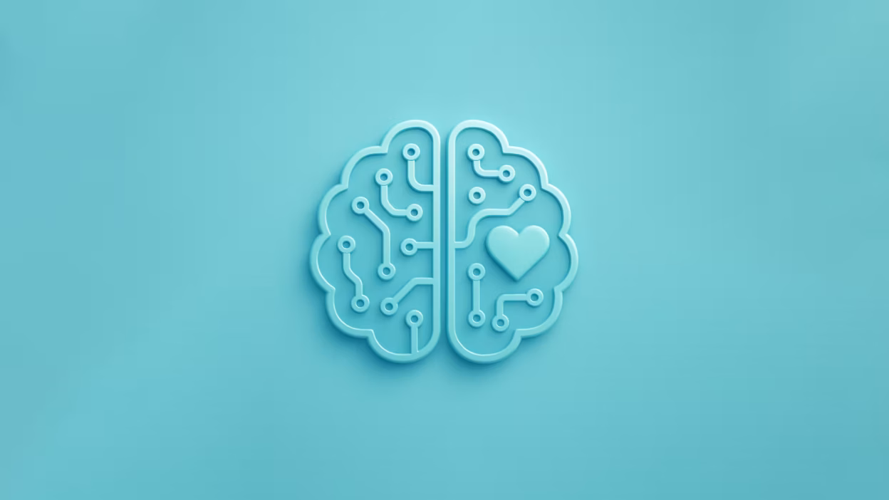 A circuit board shaped like a human brain, with a small heart integrated into the design where the amygdala would be, using a soft teal/blue color palette.